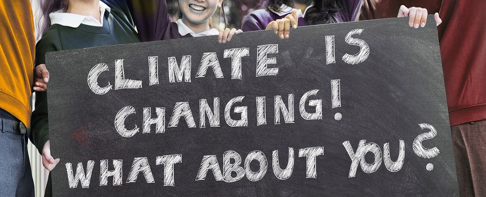 Girl activists holding a banner says "Climate is changing! what about you?" 
