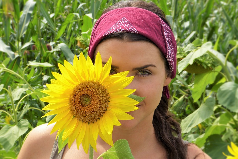 A woman holding sunflower in hand to symbolize Natural beauty