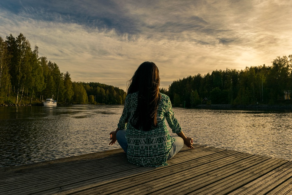 Woman doing yoga at a lake side for environmental protection